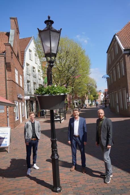 (V.li.): Jonas Berger (Citymanagement), Oberbürgermeister Dieter Krone und Marko Schnitker (stellv. Geschäftsführer LWT) bestaunen die zahlreichen Blumenampeln in der Lingener Fußgängerzone.